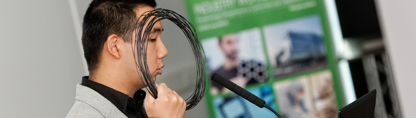 Man holding a coil of rope, speaking at a conference