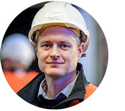 Profile of Alex McDermott smiling and wearing an industrial hard hat