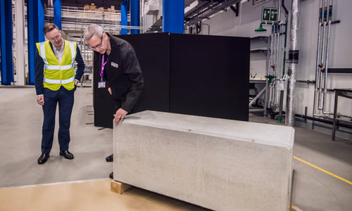Two men looking at a large slab of concretene