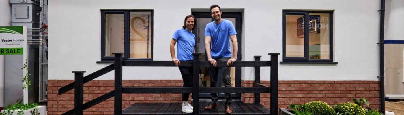 Two men stood on a balcony outside a house