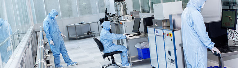 Researchers working in an NGI cleanroom wearing full PPE